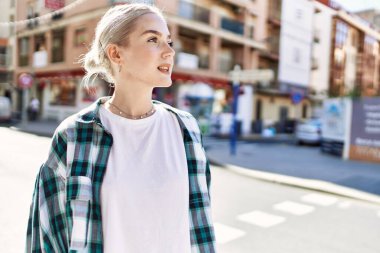 Modern beyaz saç stili ile genç ve güzel bir kadın dışarıda mutlu bir şekilde gülümsüyor.