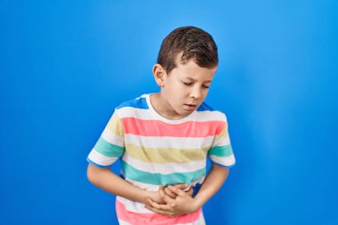 Mavi arka planda, midesi üstünde duran beyaz bir çocuk. Çünkü hazımsızlık, acı verici bir hastalık ve kendini iyi hissetmiyor. Ağrı kavramı. 