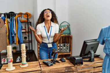 Güzel İspanyol kadın giyim mağazasında çalışıyor deli gibi bağırıyor, bağırıyor, agresif bir ifade ve kollarla bağırıyor. hüsran kavramı. 