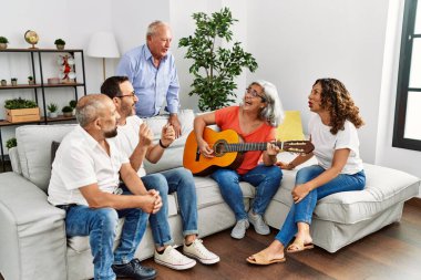 Bir grup orta yaşlı arkadaş evdeki kanepede oturup klasik gitar çalıyorlar..