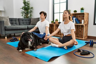 Kafkasyalı genç çift evde köpekle yoga eğitimine konsantre oluyor..