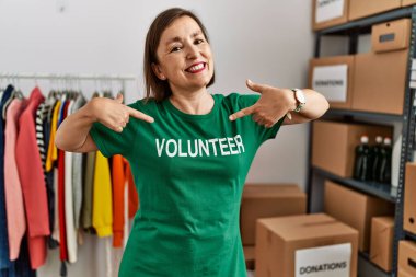 Orta yaşlı İspanyol kadın bağış standında gönüllü tişört olduğunu söylüyor.