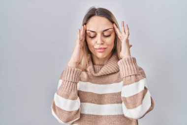 İzole edilmiş arka planda boğazlı kazak giyen genç sarışın kadın, baş ağrısı, stres yüzünden. migren ağrısı. 