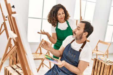 Sanat okulunda resim yapan orta yaşlı bir öğrenci ve öğretmen..