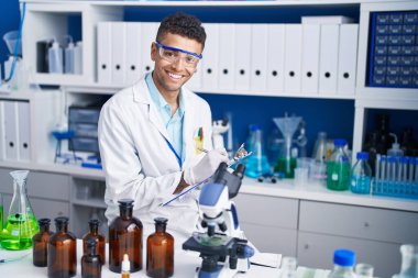 Afrikalı Amerikalı bilim adamı, laboratuardaki belgelere yazı yazıyor.