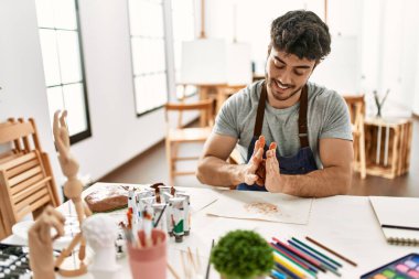 Genç İspanyol ressam gülümsüyor. Sanat stüdyosunda mutlu model çanak çömleği..