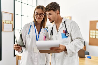 Tıbbi bir toplantıda çalışan iki İspanyol doktor klinikteki kemik taramasına bakıyor..