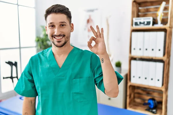 Homem Fisioterapeuta Jovem Trabalhando Clínica Recuperação Dor Sorrindo Positivo Fazendo — Fotografia de Stock