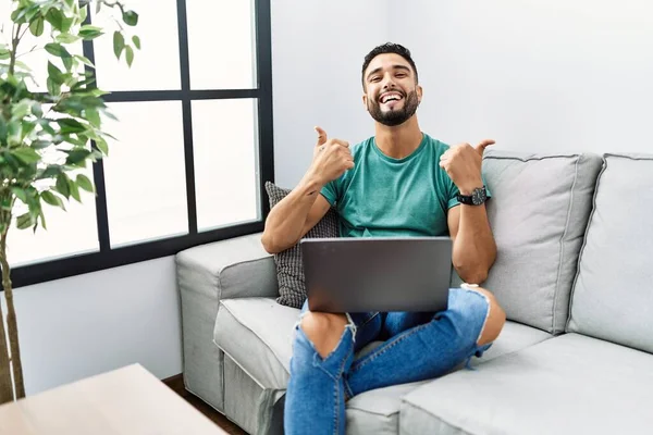 Sakallı Genç Bilgisayarlı Bir Adam Evdeki Başarı Tabelasında Koltukta Oturmuş — Stok fotoğraf