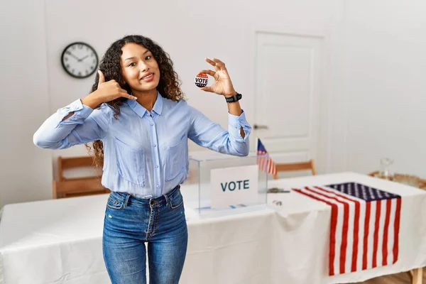 这位美丽的惊慌失措的女人站在竞选活动旁边 投票时面带微笑 用手和手指做着电话手势 就像在电话里说话一样 交流概念 — 图库照片
