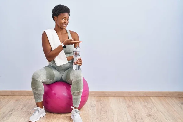 Mujer Afroamericana Vistiendo Ropa Deportiva Sentada Pelota Pilates Señalando Lado —  Fotos de Stock