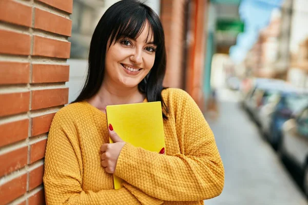 Young Brunette Woman Smiling Happy Holding Book Leaning Bricks Wall — ストック写真