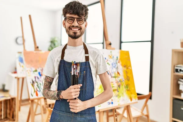 Young Hispanic Artist Man Smiling Happy Holding Paintbrushes Art Studio — Stock Photo, Image