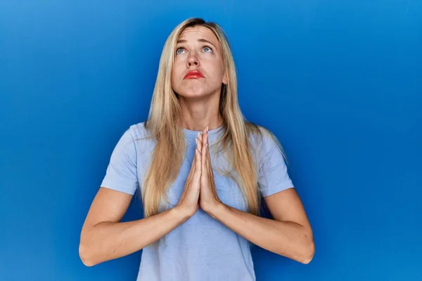 Beautiful Blonde Woman Wearing Casual Shirt Blue Background Begging Praying — Stok fotoğraf