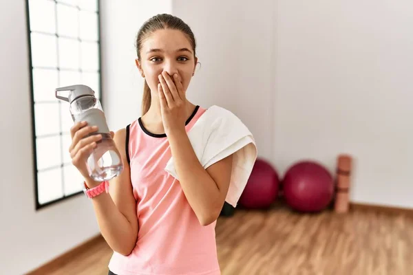 Young Brunette Teenager Wearing Sportswear Holding Water Bottle Laughing Embarrassed — Zdjęcie stockowe
