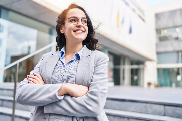 Young hispanic woman executive smiling confident standing with arms crossed gesture at street