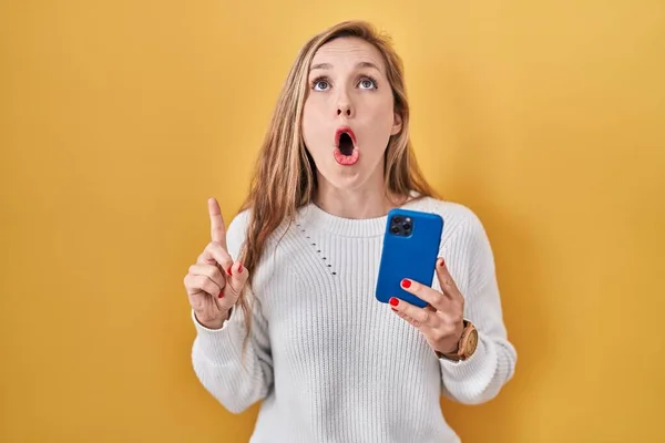 Junge Blonde Frau Mit Smartphone Tippnachricht Erstaunt Und Überrascht Blick — Stockfoto