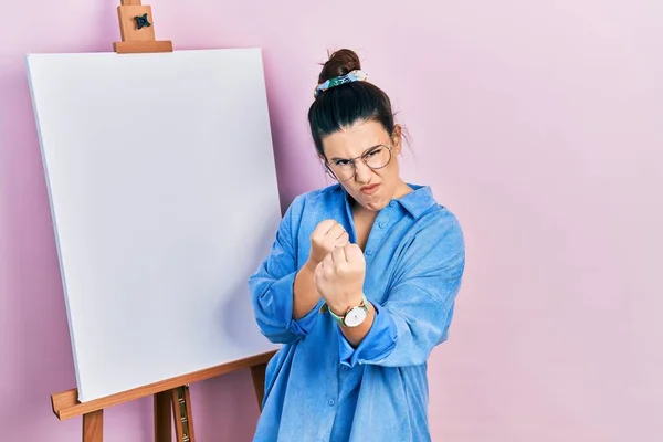 Young Hispanic Woman Standing Painter Easel Stand Ready Fight Fist — ストック写真