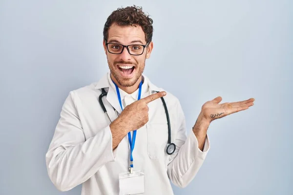 Jonge Spaanse Man Draagt Doktersuniform Stethoscoop Verbaasd Glimlachend Naar Camera — Stockfoto