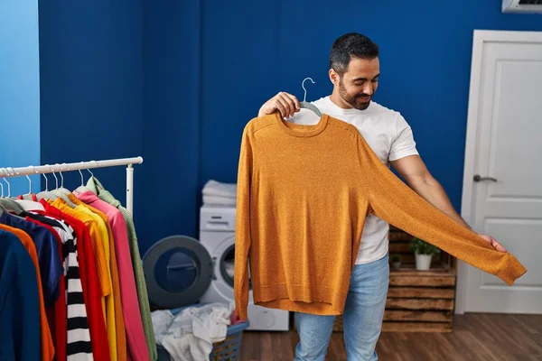 Young Hispanic Man Holding Sweater Laundry Room — Stockfoto