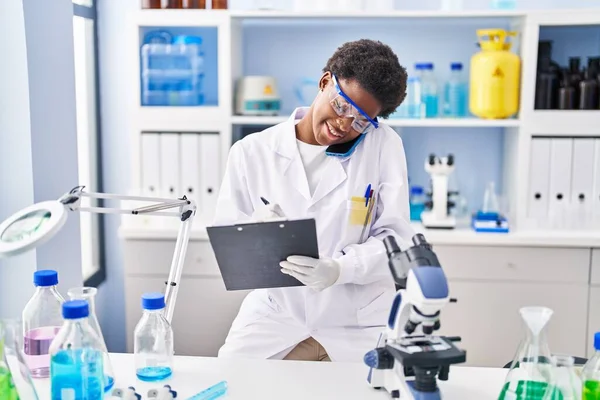 Mujer Afroamericana Vistiendo Uniforme Científico Hablando Teléfono Inteligente Escribir Portapapeles —  Fotos de Stock