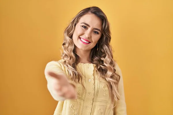 Young Caucasian Woman Standing Yellow Background Smiling Friendly Offering Handshake — Fotografia de Stock