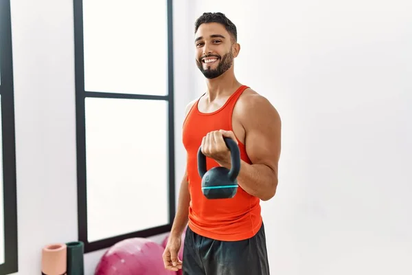 Hombre Árabe Joven Sonriendo Entrenamiento Seguro Con Kettlebell Centro Deportivo — Foto de Stock