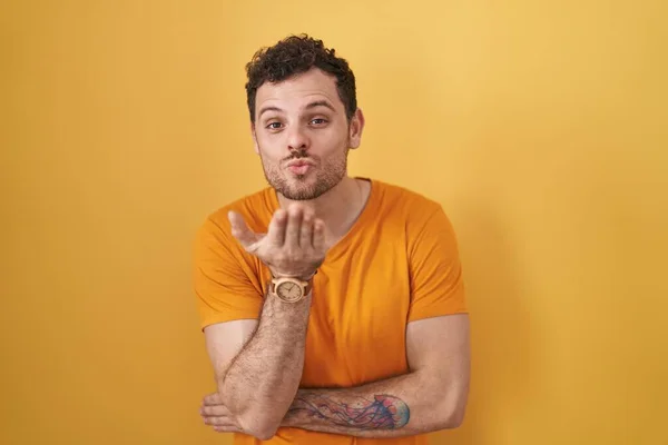 Young Hispanic Man Standing Yellow Background Looking Camera Blowing Kiss — Stock Photo, Image