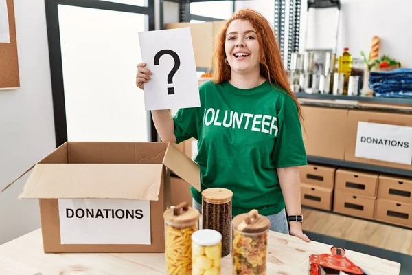 Young Redhead Woman Wearing Volunteer Shirt Holding Question Mark Looking — Stock Photo, Image
