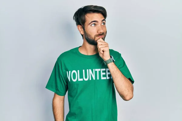 Jovem Hispânico Vestindo Camiseta Voluntária Com Mão Queixo Pensando Questão — Fotografia de Stock