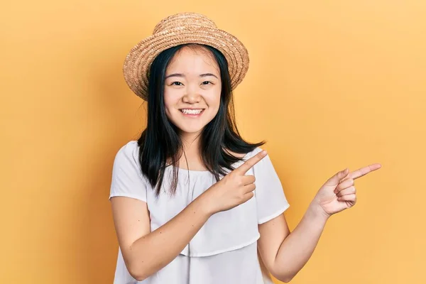 Young Chinese Girl Wearing Summer Hat Smiling Looking Camera Pointing — Stockfoto