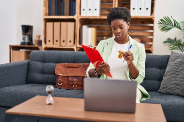 Psikoloji merkezinde telekonksiyon reçetesi yazan Afrikalı Amerikalı kadın psikolog.