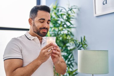 Genç İspanyol adam gülümsüyor. Evde kendine güvenen bir mum kokusu var.