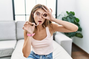 Görünmez hizada duran genç sarışın kadın ok hareketi yapıyor. Şaşırmış bir yüz ve parmaklarından bakan gözlerle şok olmuş. İnançsız ifade. 