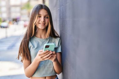 Adorable girl smiling confident using smartphone at street