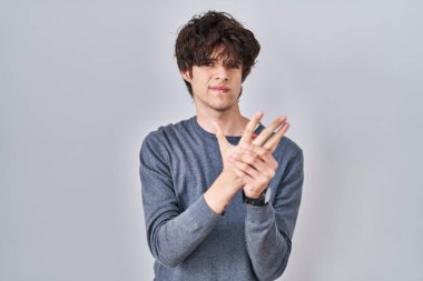 İzole edilmiş arka planda duran genç adam ellerinde ve parmaklarında ağrı, eklem iltihabı. 