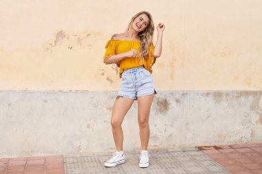 Young woman smiling confident dancing at street