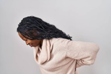 African woman standing over white background suffering of backache, touching back with hand, muscular pain 