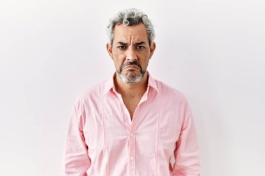 Orta yaşlı İspanyol bir adam soyutlanmış arka planda duruyor. Depresyonda ve endişe içinde, sinirli ve korkmuş bir şekilde ağlıyor. hüzünlü ifade. 