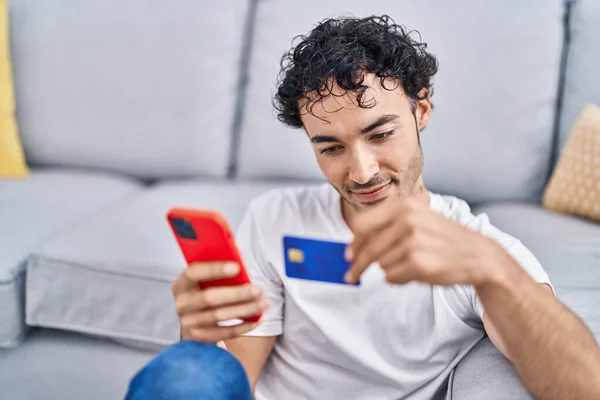 Young Hispanic Man Using Smartphone Credit Card Sitting Floor Home — Foto Stock