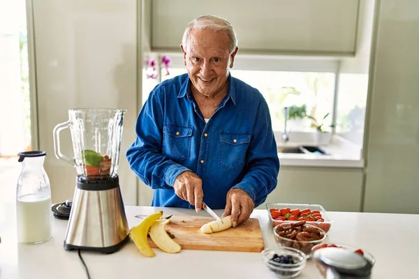 Senior Man Smiling Confident Cutting Banana Kitchen — Foto de Stock