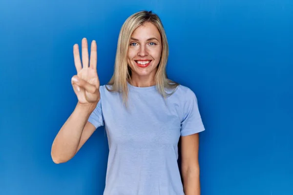 Красива Блондинка Повсякденній Сорочці Синьому Фоні Показуючи Вказуючи Пальцями Номер — стокове фото