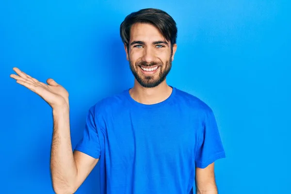 Mladý Hispánec Nosí Ležérní Oblečení Vesele Usmívá Ukazuje Dlaní Ruky — Stock fotografie