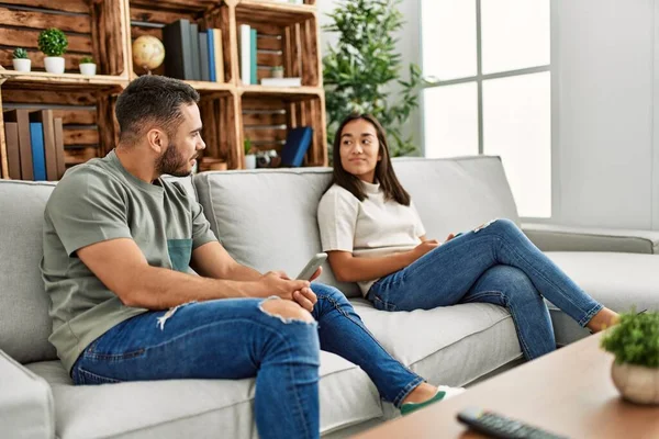 Jovem Casal Latino Com Expressão Séria Usando Smartphone Casa — Fotografia de Stock