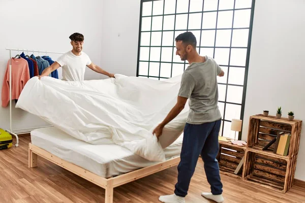 Two Hispanic Men Couple Smiling Confident Make Bed Bedroom — ストック写真