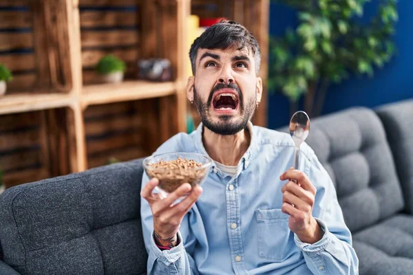 Young Hispanic Man Beard Eating Healthy Whole Grain Cereals Angry — Stockfoto