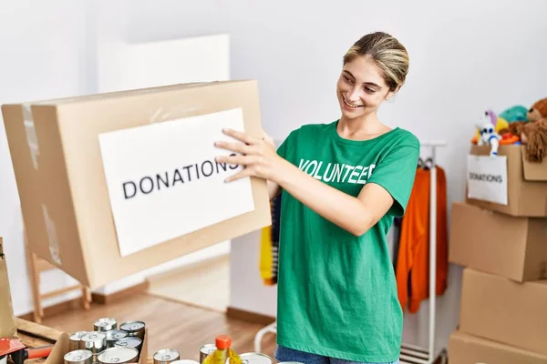 Jovem Caucasiana Vestindo Uniforme Voluntário Segurando Caixa Doações Centro Caridade — Fotografia de Stock