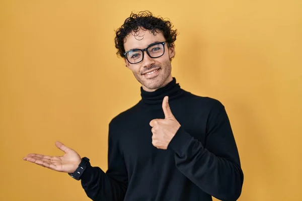 Hispanic Man Standing Yellow Background Showing Palm Hand Doing Gesture — Stockfoto