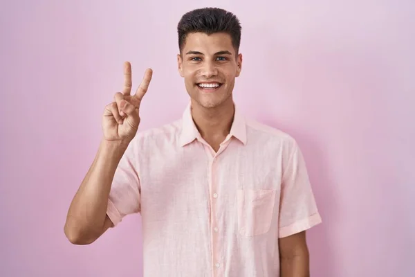 Young Hispanic Man Standing Pink Background Showing Pointing Fingers Number — ストック写真