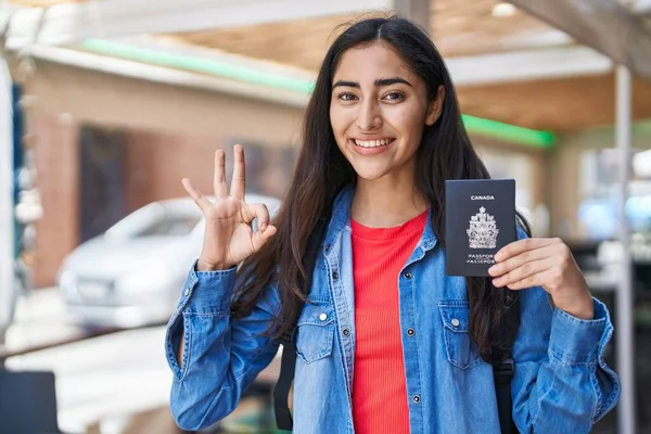 持有加拿大护照的少女用手指签了名 微笑着表示友善的手势 是个很好的象征 — 图库照片